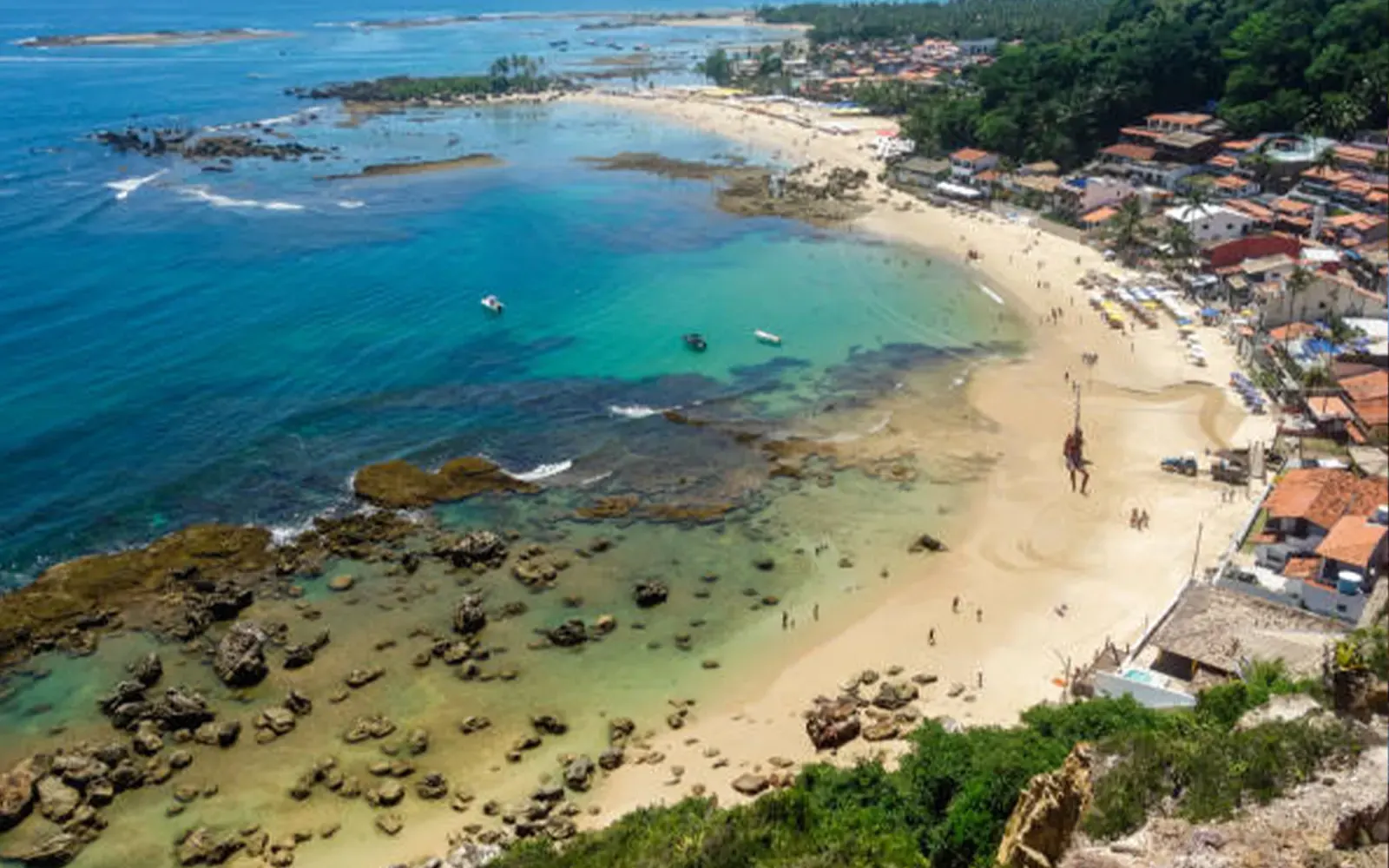 Enseada de Morro de São Paulo Enseada de Morro de São Paulo com recifes rasos, lanchas fundeadas e guarda-sóis na areia